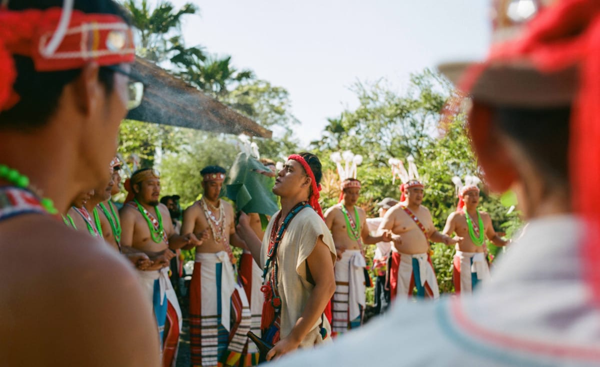 Tribal community members encircle Kulas Umo, a prominent Sikawasay, in ritual dance and song as he spits rice wine to cleanse the ceremony and commune with ancestral spirits in Fata'an, Hualien County (Nathaniel Brown/Washington Post via Getty Images)