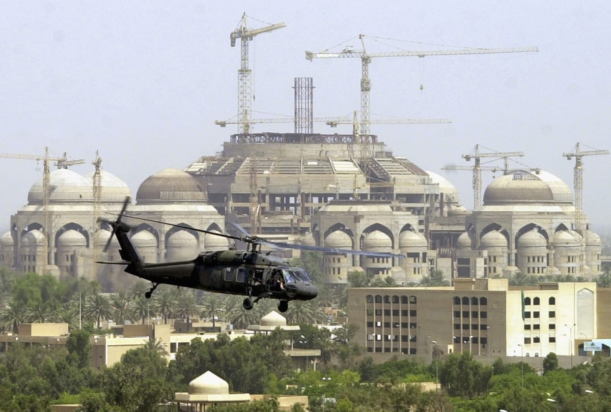 U.S. military helicopter carrying Iraq's U.S. administrator L. Paul Bremer flies over the city on June 21, 2004 in Baghdad, Iraq. (Photo by Khalid Mohammed-Pool/Getty Images)