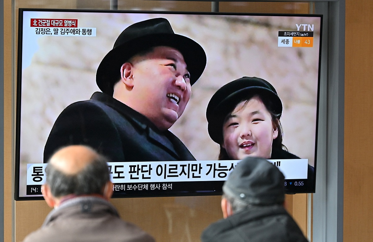A news broadcast shows North Korean leader Kim Jong-un and his daughter, presumed to be named Ju Ae, attending a military parade in Pyongyang (Jung Yeon-je/AFP via Getty Images)