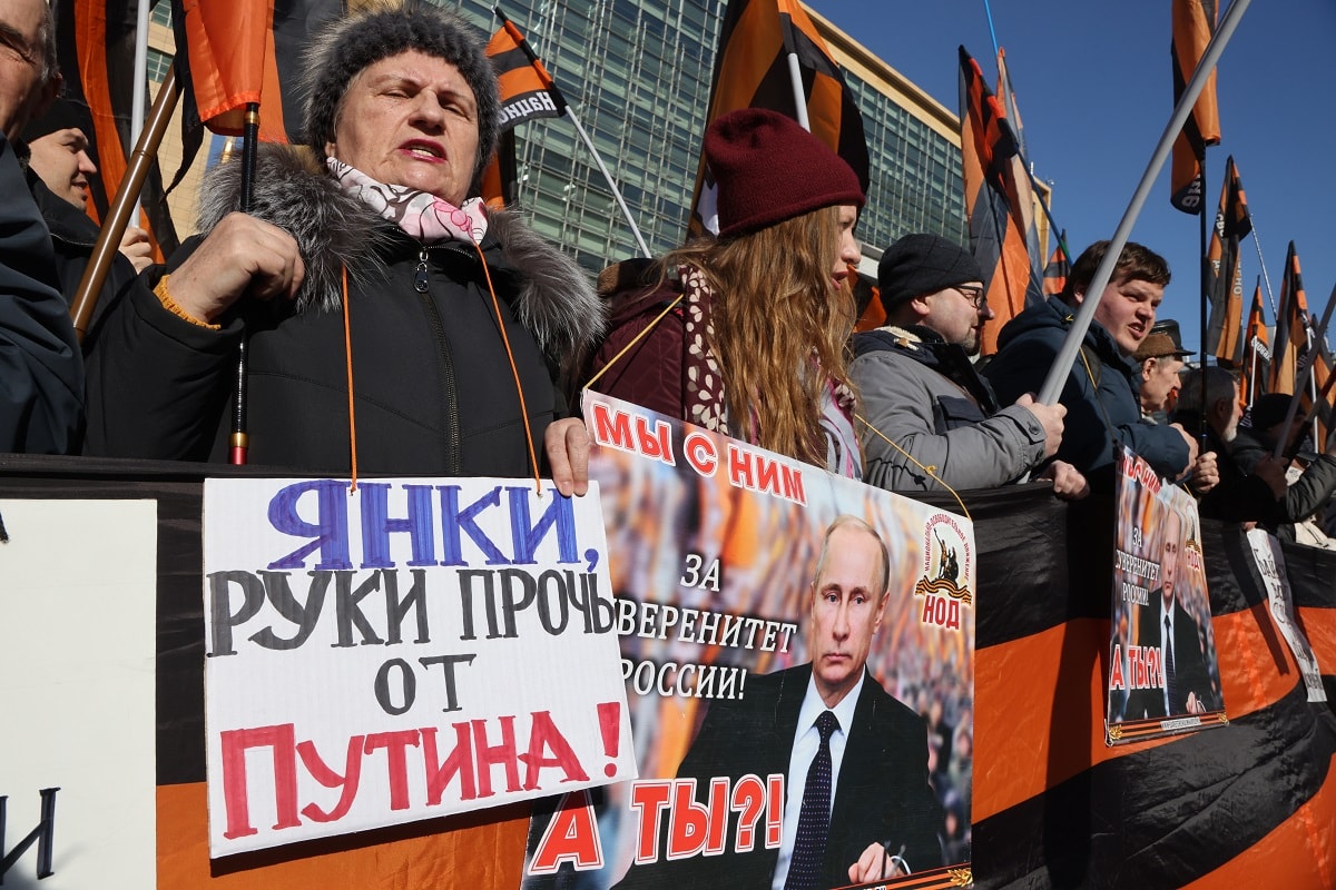 MOSCOW, RUSSIA - MARCH,19 (RUSSIA OUT) Activists of pro-Putin's National Liberation Movement (NOD) hold a poster that reads:"Yankees! Hands off Putin" during a protest rally outside of U.S. Embassy, March,19,2023, in Moscow, Russia. Hundreds people gathered in front of the Embassy of USA to protest against the International Criminal Court (ICC) in the Hague who issued an arrest warrant for Russian President Vladimir Putin for war crimes and to demand Russian authorities to cancel United States - Russia mutual detargeting agreement, signed in 1994 by U.S.President Bill Clinton and Russian President Boris Yeltsin. (Photo by Contributor/Getty Images)