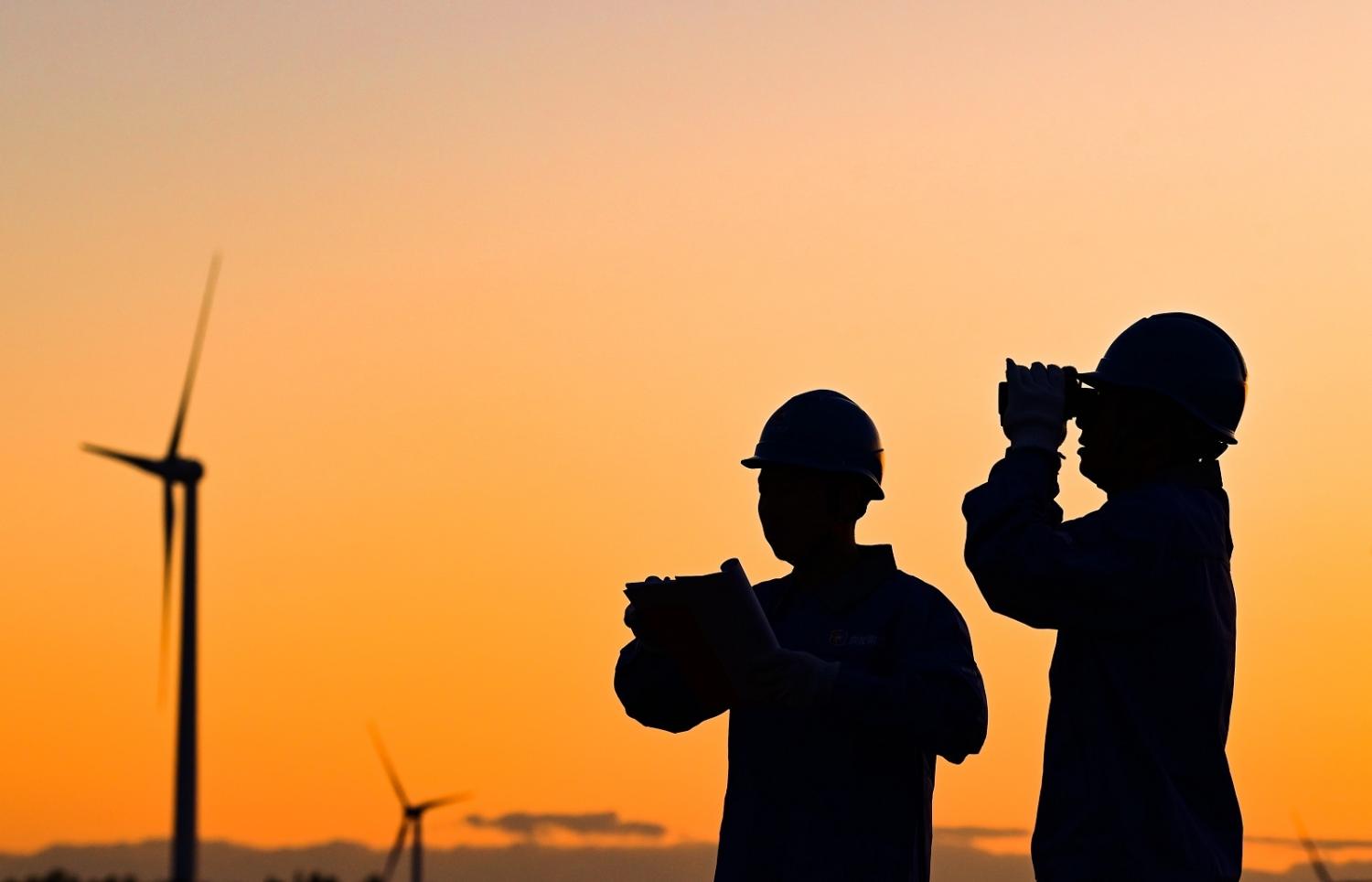 Workers inspect a wind power photovoltaic field in Ulanhot, Innner Mongolia on 23 May 2023 (CFOTO/Future Publishing via Getty Images)