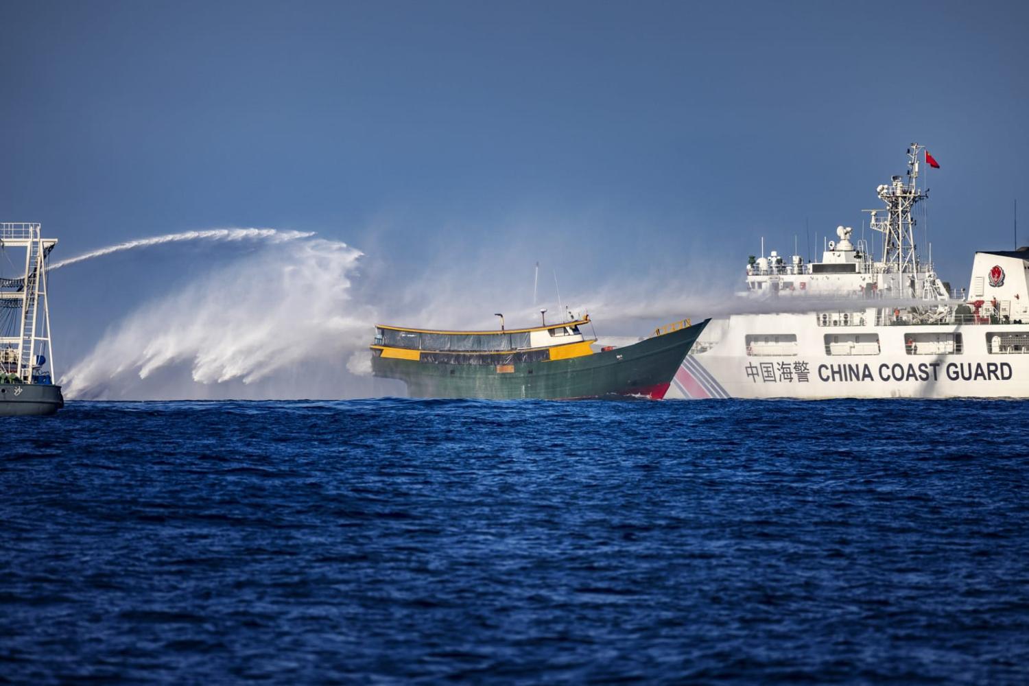Chinese Coast Guard ships fire water cannons at a Philippine Navy chartered vessel attempting to resupply troops stationed at Second Thomas Shoal in the South China Sea, 5 March 2024 (Ezra Acayan/Getty Images)