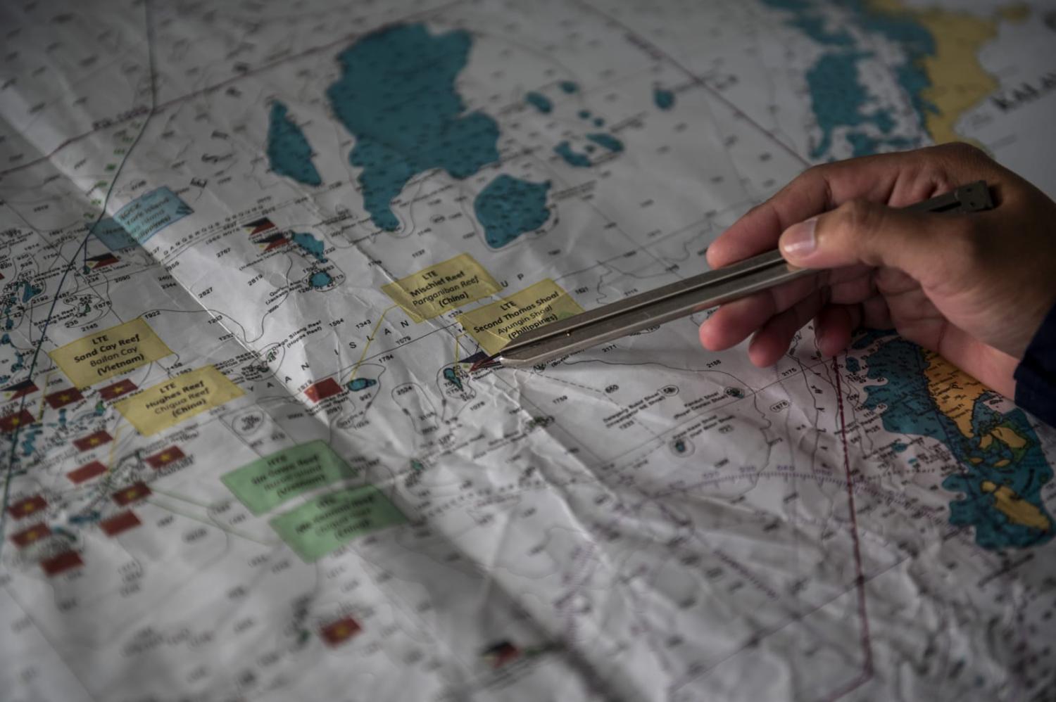 Philippine Coast Guard personnel with a map ahead a resupply mission for the BRP Sierra Madre in the Second Thomas Shoal in the South China Sea, 9 November 2023 (Lisa Marie David/Bloomberg via Getty Images)