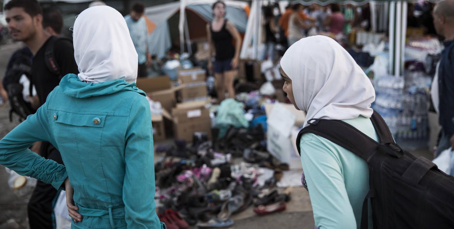 Sisters wait at a before crossing in Greece in 2015 (Photo: IOM/Flickr)