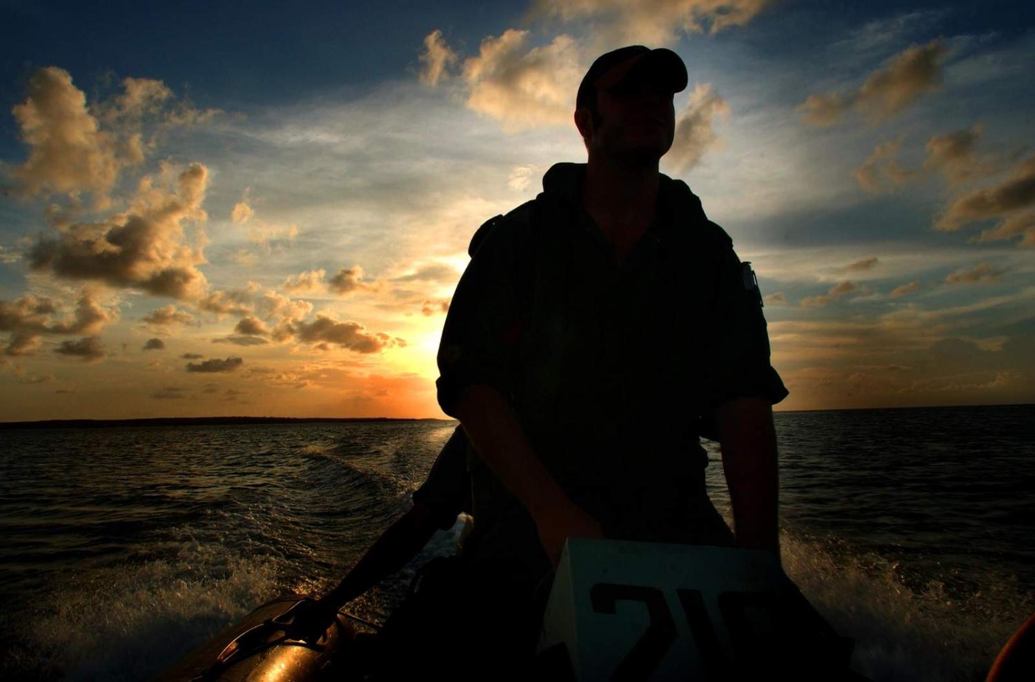 An Australian Navy marine technician from HMAS Cessnock searches bays for illegal fishing boats during Operation Cranberry (LSP Kaye/Defence Images)