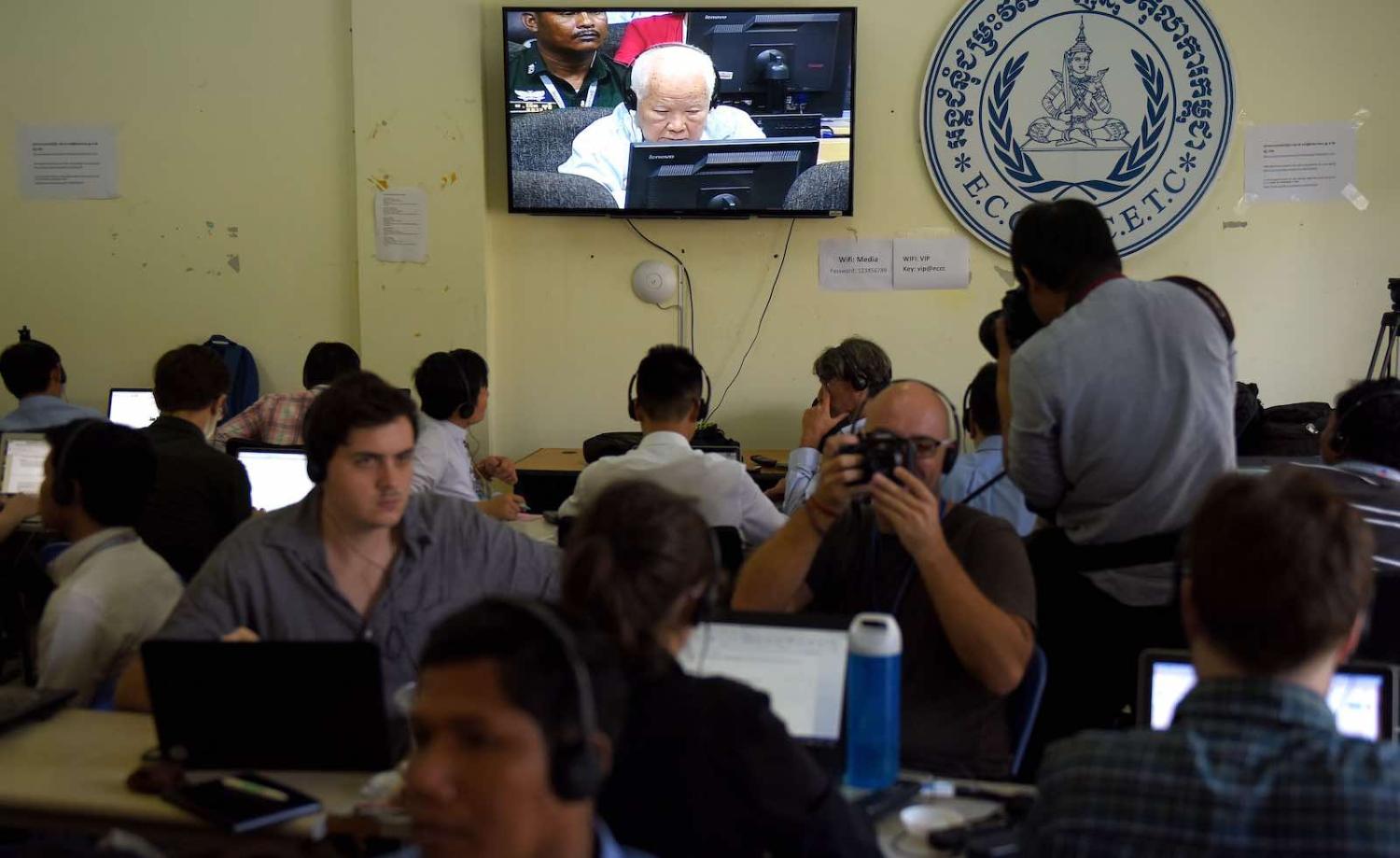 Journalists watch the verdict for former Khmer Rouge leader Khieu Samphan shown on a live video broadcast on 16 November (Photo: Tang Chhin Sothy via Getty)