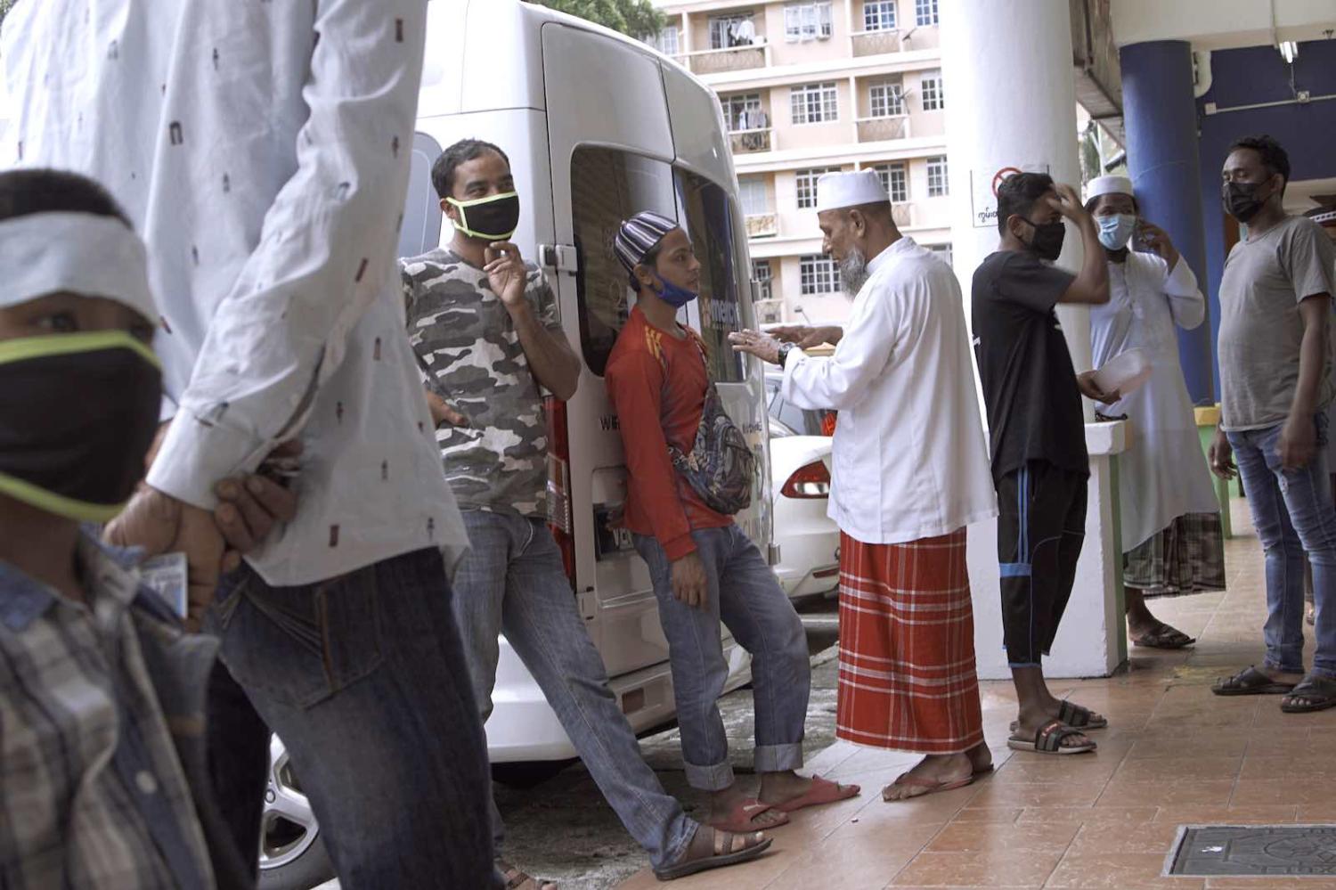 A group of Rohingya refugees wait to be screened for Covd-19 at a health clinic in Kuala Lumpur, 24 March (Rahman Roslan/Getty Images)