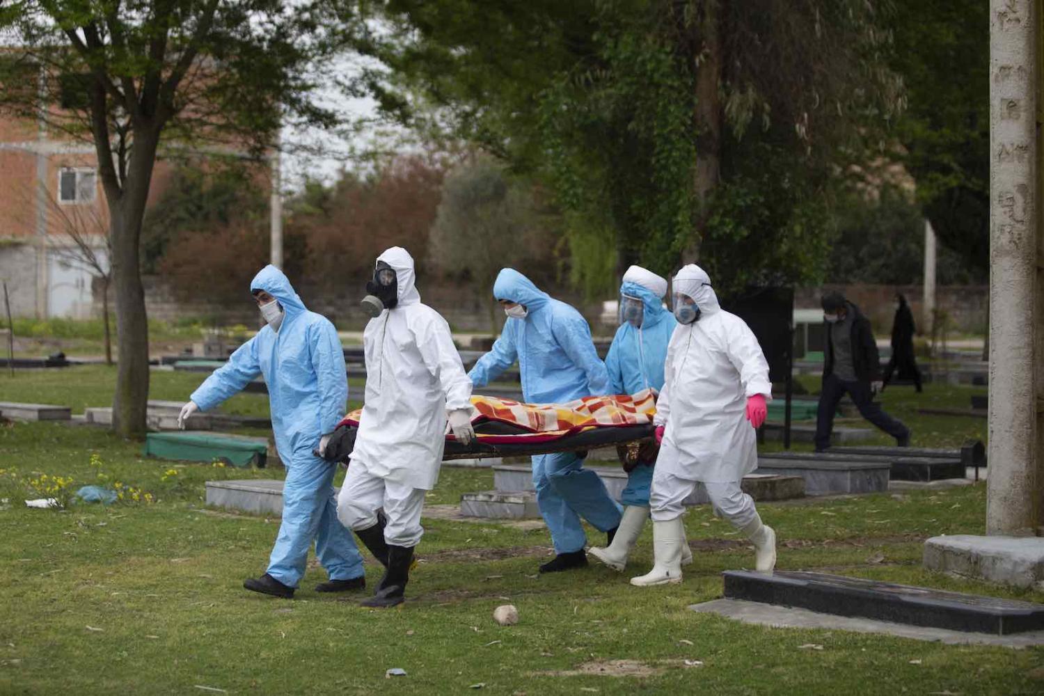 Volunteers carry the body of a Covid-19 victim for burial in Qaem Shahr, Iran, 10 April (Majid Saeedi/Getty Images)