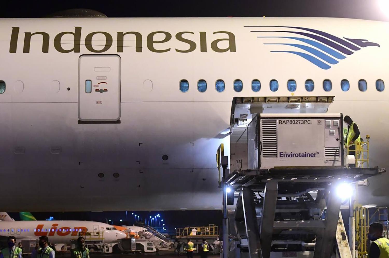 Unloading the Covid-19 vaccine made by Sinovac upon its arrival from Beijing at the Jakarta International Airport, 6 December (Indonesian Presidential Palace/AFP via Getty Images)