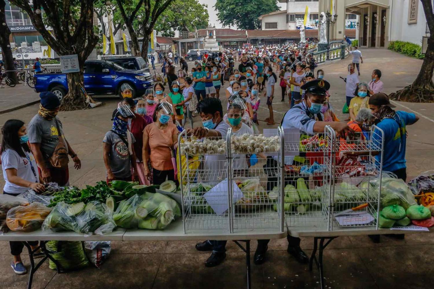 Locals wait in line to receive goods at a community pantry in Antipolo City, Philippines (Ryan Eduard Benaid/NurPhoto via Getty Images)