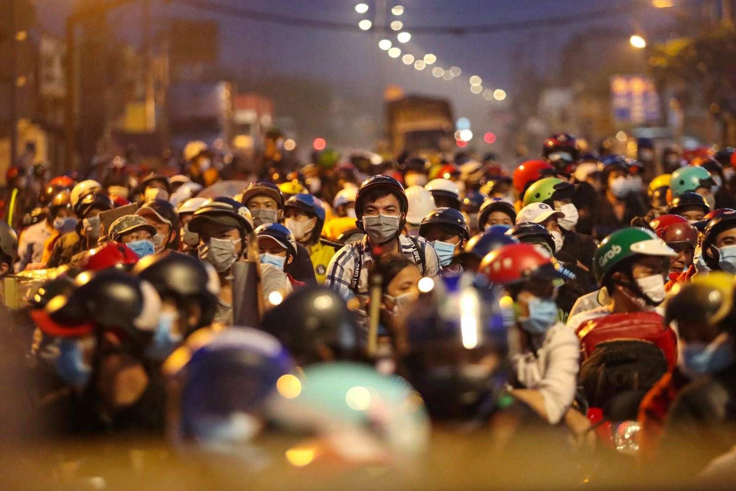 People planning to return to their hometowns wait at a checkpoint to leave Ho Chi Minh City in the early hours of 1 October (Chi Pi/AFP via Getty Images)