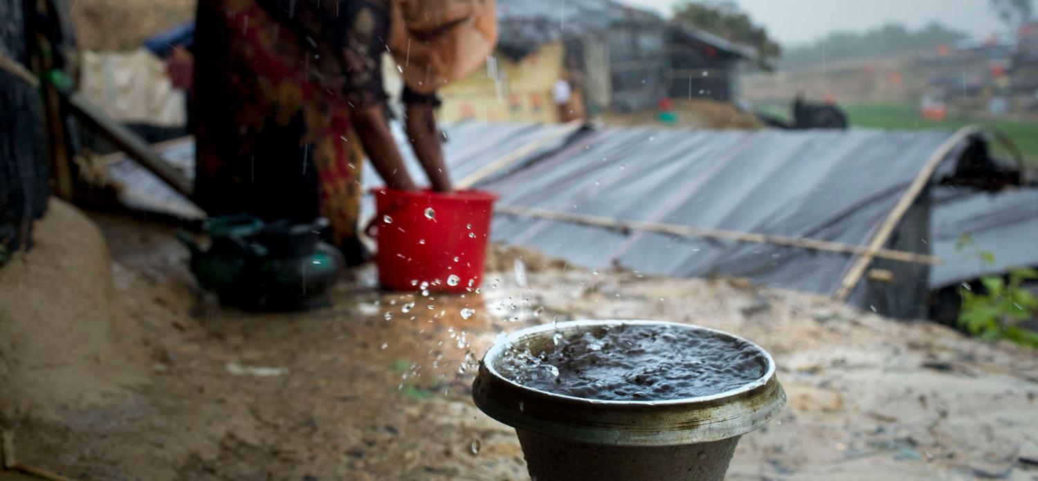 A Rohingya refugee collects drinking water in heavy rain at Ukhiya, Cox's Bazar (Photo by K M Asad/Getty)