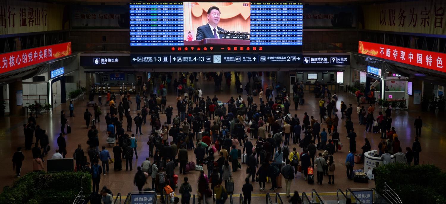 Passengers watch a broadcast of the opening ceremony for the 19th Party Congress at a Beijing railway station, October 2017 (Photo: VCG/Getty Images)