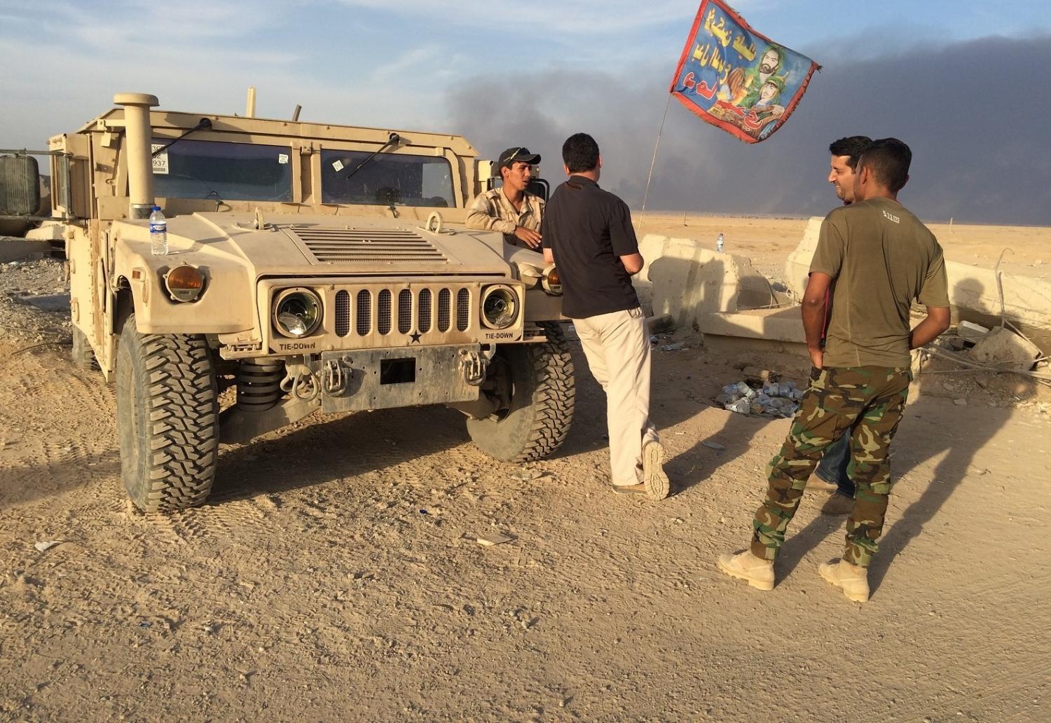 The author interviewing Iraqi soldiers displaying Shiite flags.