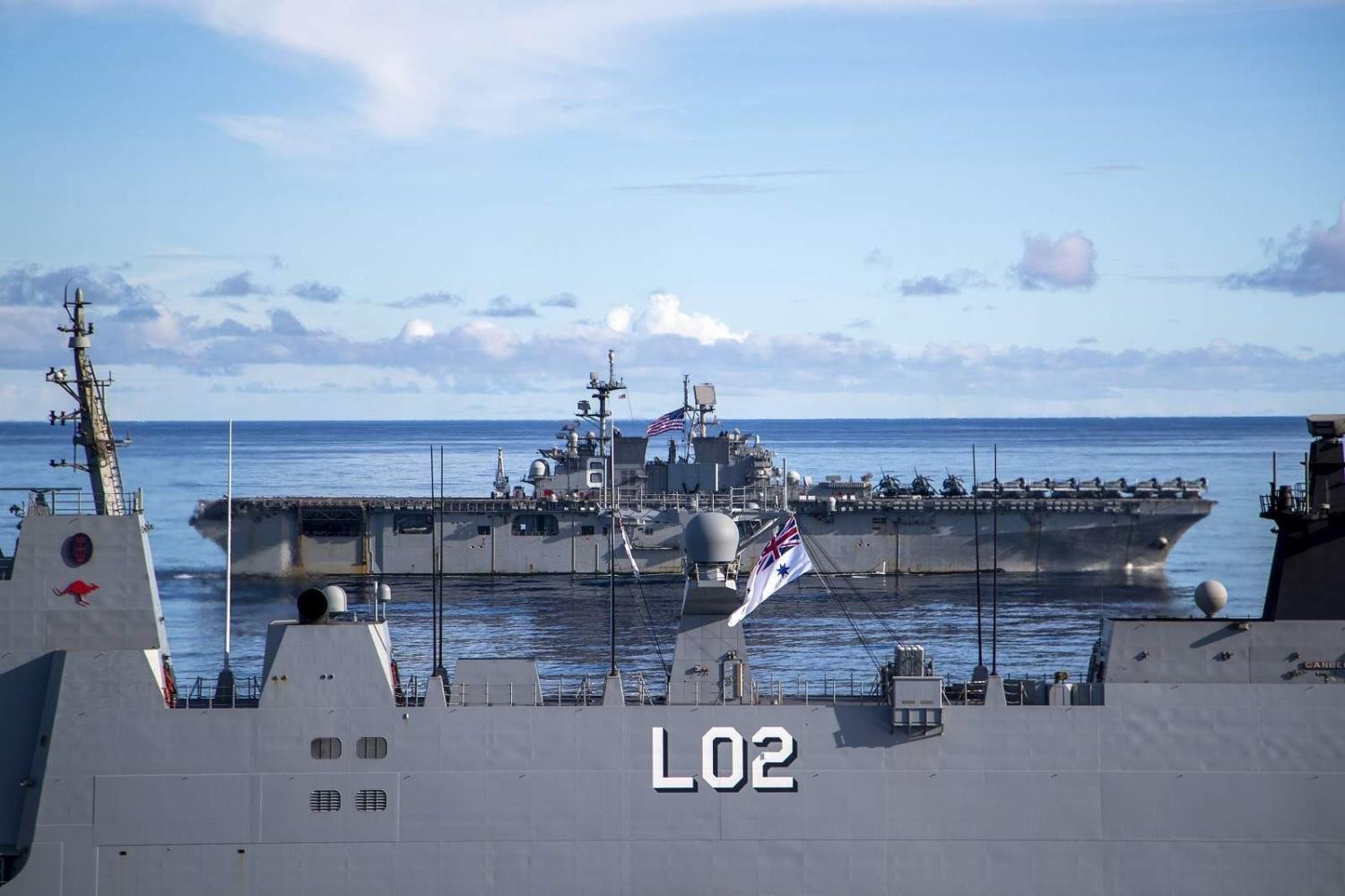 The Royal Australian Navy landing helicopter dock HMAS Canberra and the amphibious assault ship USS America conduct maritime manoeuvres during the US-led Large Scale Global Exercise 21 in the Western Pacific, 5 August 2021 (US Navy/Flickr)