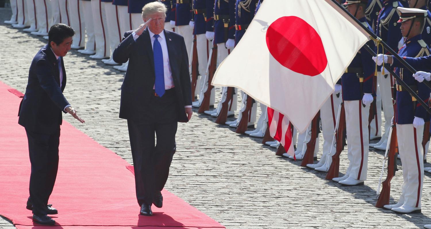 President Donald Trump and Prime Minister Shinzo Abe walk past honour guards at Akasaka Palace in Tokyo on 6 November. (Photo by Koji Sasahara/Getty)